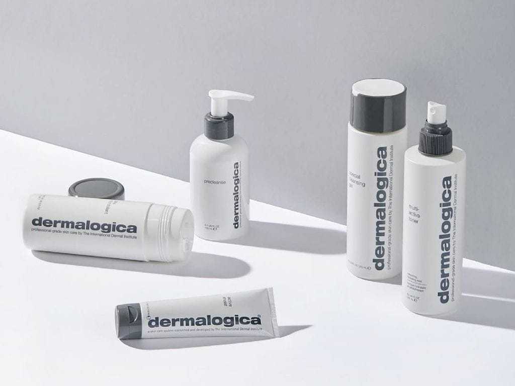 Dermalogica skincare products on a white surface with shadow play in a minimalist setting.